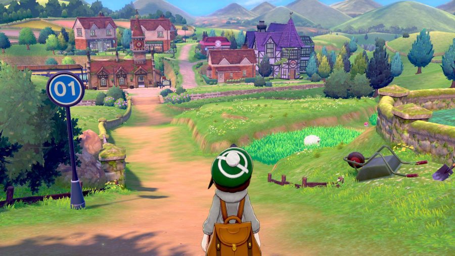 Un dresseur de pokémon surplombe la campagne de Galar, avec plusieurs routes et villes visibles devant lui 